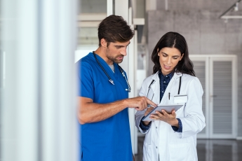 Two individuals looking over a medical sheet